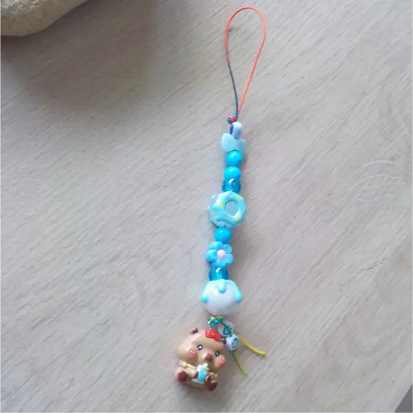 Bijou de telephone grigri de sac bébé capybara capibala mignon biberon perles acryliques donuts noeud papillon bleu fleurs