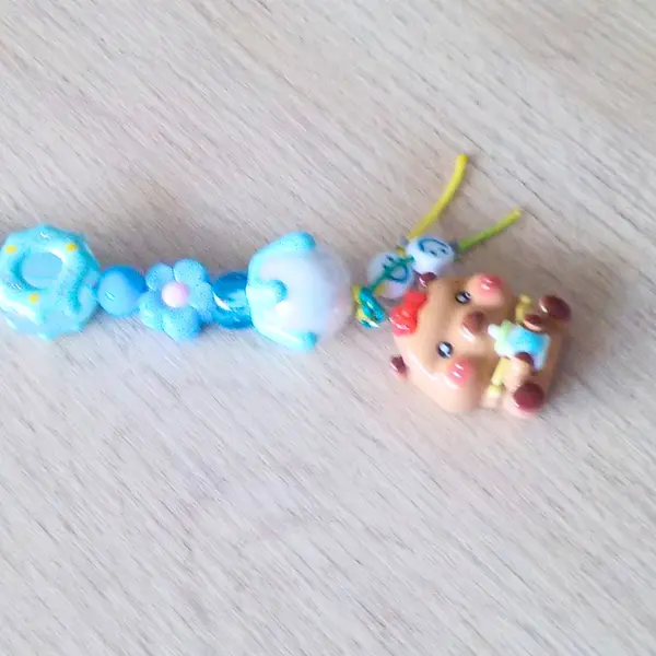Bijou de telephone grigri de sac bébé capybara capibala mignon biberon perles acryliques donuts noeud papillon bleu fleurs